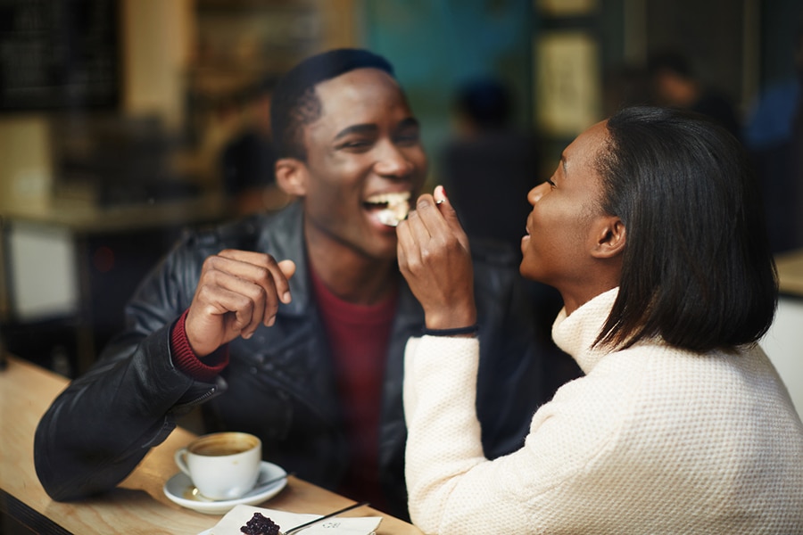 Happy couple eating dessert and drinking coffee