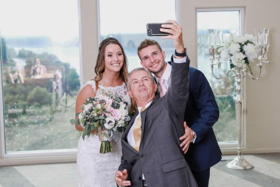 Bride and groom selfie with the officiate