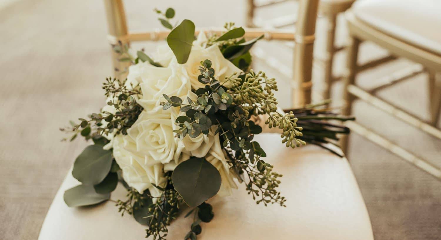 Bouquet of white flowers placed on white cushioned chair
