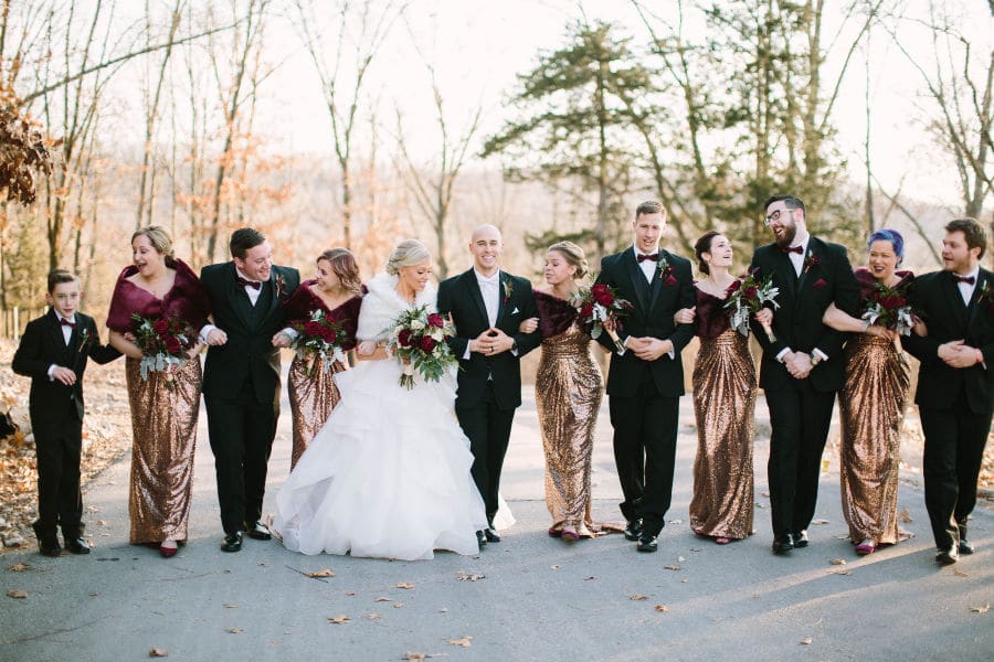 Winter wedding party laughing outside Missouri wedding venue 